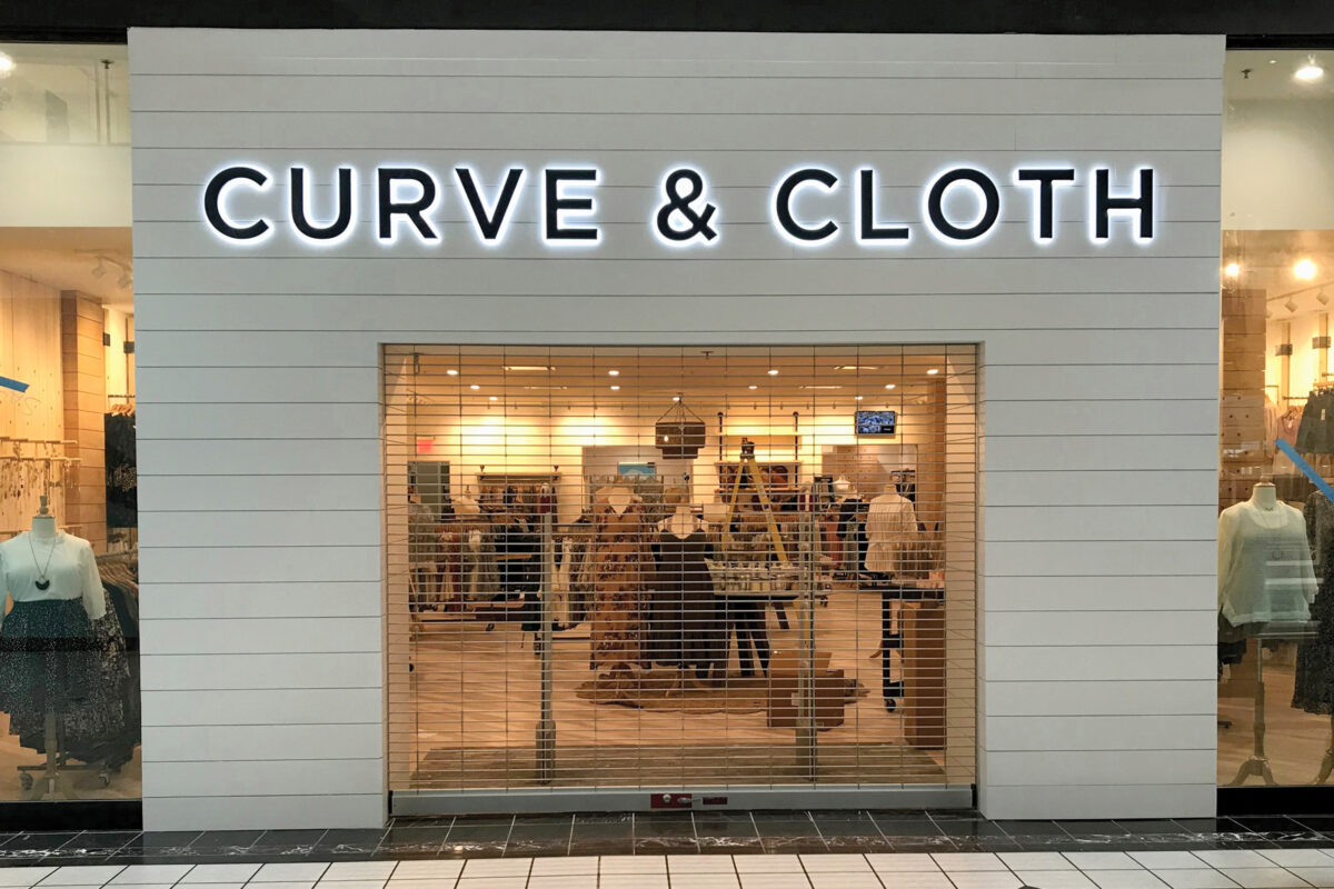 Side-lit acrylic Curve and Cloth letters above a storefront entrance